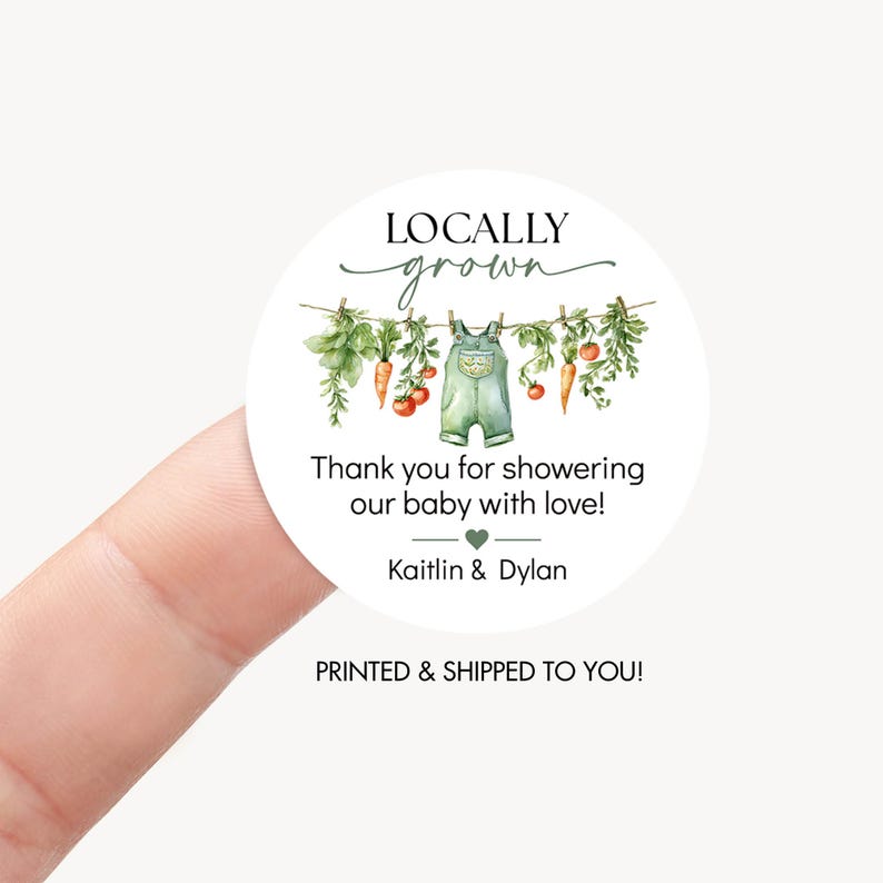 May include: A round sticker with the text "LOCALLY grown" above a watercolor illustration of vegetables and baby overalls hanging on a clothesline. The text "Thank you for showering our baby with love!" is below the illustration, with names and a heart symbol.