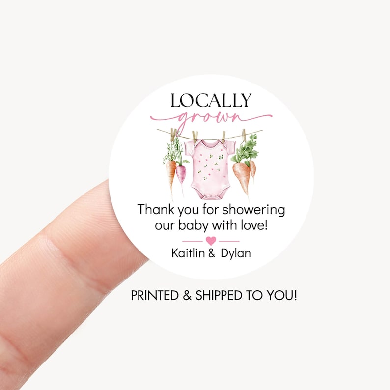 May include: A round sticker with the text "LOCALLY grown" in pink script. Below, it reads "Thank you for showering our baby with love!" and the names "Kaitlin & Dylan." The design includes a baby onesie, carrots, and greenery.