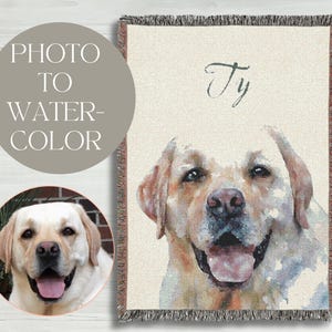 May include: A woven throw blanket featuring a watercolor portrait of a yellow Labrador Retriever. The dog's name, "Ty", is written in cursive. A smaller circular image of the dog is also present, along with the text "PHOTO TO WATER-COLOR".