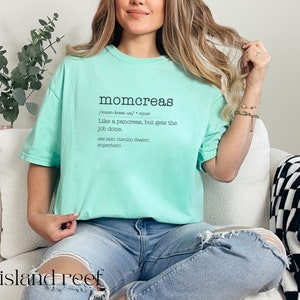 May include: A light blue t-shirt with the text "momcreas /mom-kree-us/ noun Like a pancreas, but gets the job done. see also insulin dealer, superhero" printed on the front.