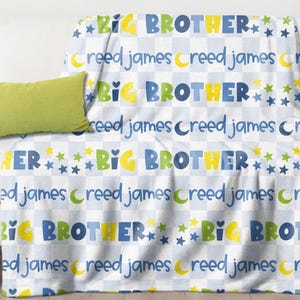 May include: A white sofa with a green pillow and a blanket draped over it. The blanket has a repeating pattern of the words "BIG BROTHER" in blue, yellow, and green, along with the name "Creed James" and star and moon graphics.