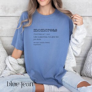 May include: A blue t-shirt with the word "momcreas" defined as "like a pancreas, but gets the job done." The text is in black and the shirt is worn by a person sitting on a couch.