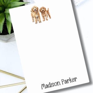 May include: White notepad with a watercolor illustration of two golden doodle dogs. The notepad has the name "Madison Parker" printed at the bottom.