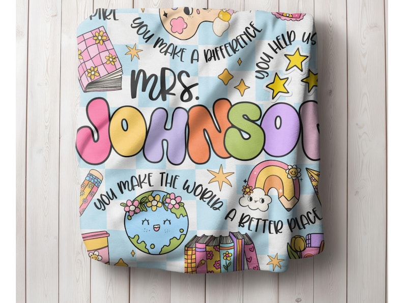 May include: A blue and white checkered fabric with the text "You make a difference" and "You help us". The text "Mrs. Johnson" is in large, colorful letters. The fabric also features a rainbow, a globe, and a stack of books.