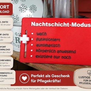 Könnte beinhalten: Ein rotes rechteckiges Schild mit weißem Text "Nachtschicht-Modus" und Aufzählungszeichen. Ein weißes Kreuz ist an der Seite befestigt. Das Schild hat auch Text auf Deutsch und wird als Geschenk für Krankenschwestern beschrieben.