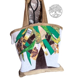 May include: A handmade tote bag with a tree design. The bag features a patchwork design with green, brown, and tan fabrics. The bag has a corduroy exterior and a light-colored interior. The bag has a corduroy handle and trim.