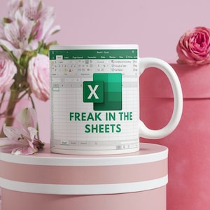 White ceramic 11oz Freak In The Sheets Excel mug with a graphic showing an Excel spreadsheet and the words Freak in the sheets. Perfect funny gift for a coworker, boss and friend. Perfect spicy Valentines Day Gifts!