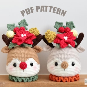 May include: Two crocheted reindeer ornaments with red poinsettia flowers and green holly on their heads. The reindeer are brown and gray with white faces and red noses.  The reindeer are wearing green and orange crocheted collars.