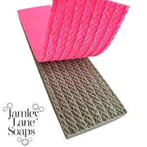 May include: A close-up of a gray silicone mold with a rope texture. The mold is flexible and can be used to create soap, fondant, or other crafts. The mold is shown with a pink backing sheet.