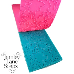 May include: Two silicone molds for soap making. The top mold is pink and the bottom mold is teal blue. Both molds have a wavy, abstract pattern.