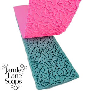 May include: Two silicone molds for crafting, one pink and one teal. The pink mold has a delicate floral pattern, while the teal mold has a more geometric pattern of overlapping leaves.