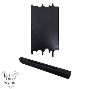 May include: Black silicone mold for making soap in the shape of a dripping candle. The mold is shown with a black silicone base.