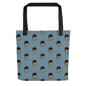 May include: A blue tote bag with a repeating pattern of pixelated faces. The faces are brown with black hair.