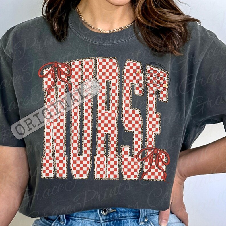 Peut inclure: T-shirt gris fonc&eacute; avec le mot "NURSE" en grandes lettres &agrave; carreaux rouges et blancs. Les lettres sont soulign&eacute;es d'un motif l&eacute;opard et orn&eacute;es de n&oelig;uds rouges. Un collier en cha&icirc;ne dor&eacute;e est visible.