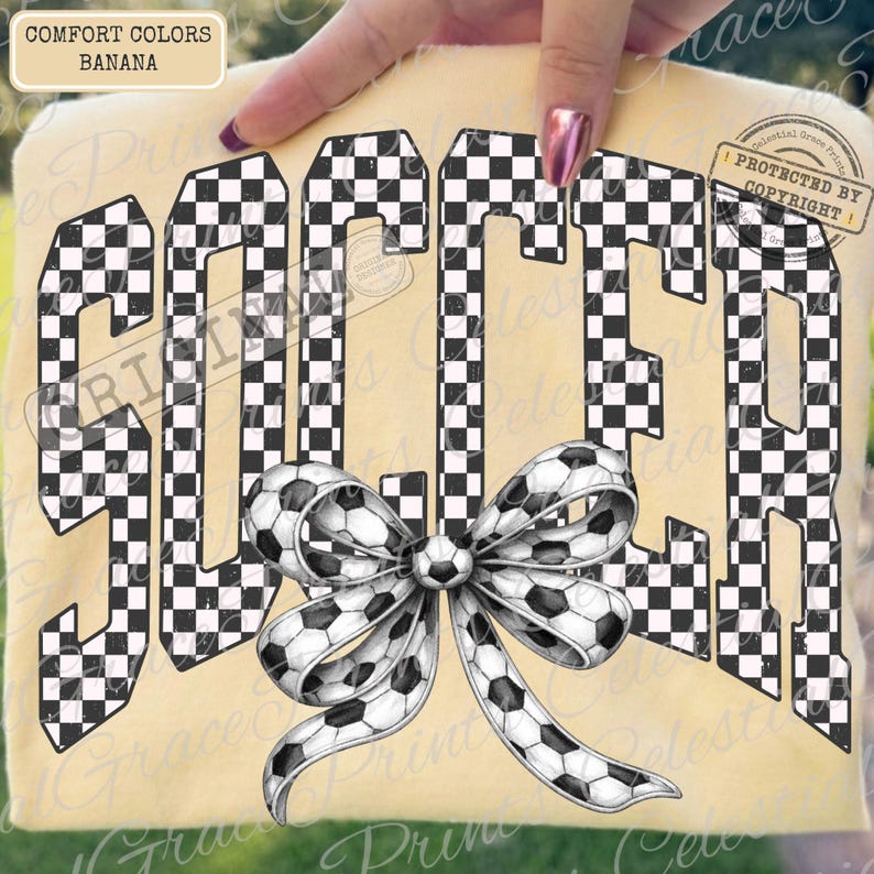 May include: A banana-colored t-shirt with the word "SOCCER" in large, checkered letters. A soccer ball bow is centered below the word. The shirt is held up by a hand.