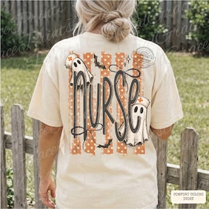 May include: An ivory short-sleeve t-shirt featuring a back graphic with the word nurse in large black script. The design includes two ghost figures wearing nurse caps, orange and white vertical stripes, small bats, and stars.