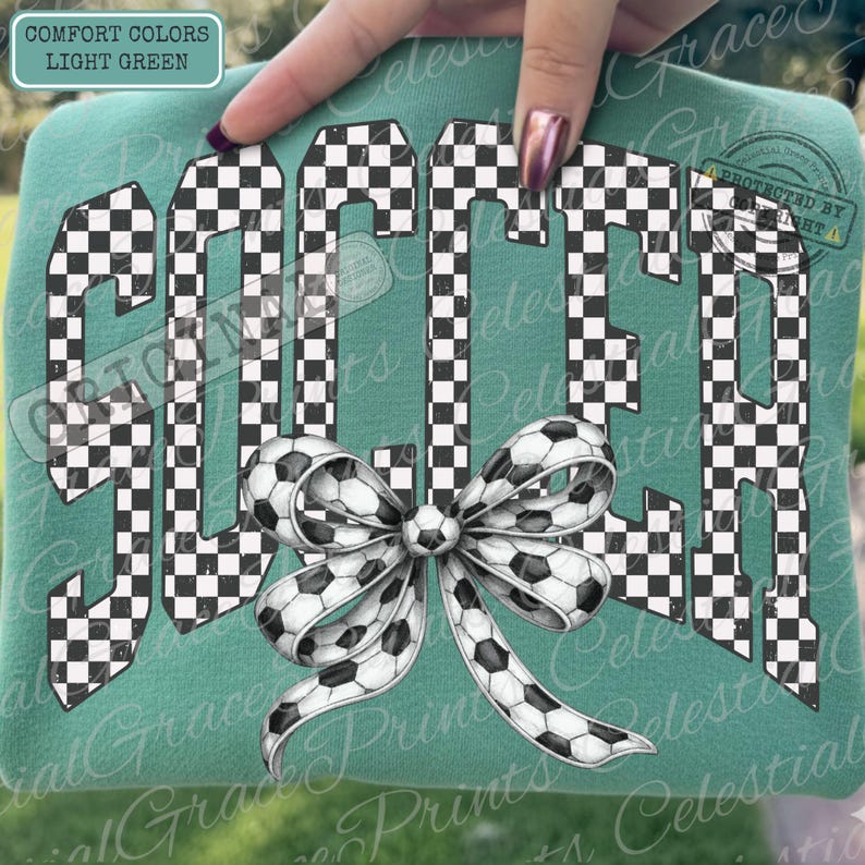 May include: Light green sweatshirt with the word "SOCCER" in a checkered pattern. A bow made of soccer balls is at the bottom. The text "COMFORT COLORS LIGHT GREEN" is in the upper left corner.