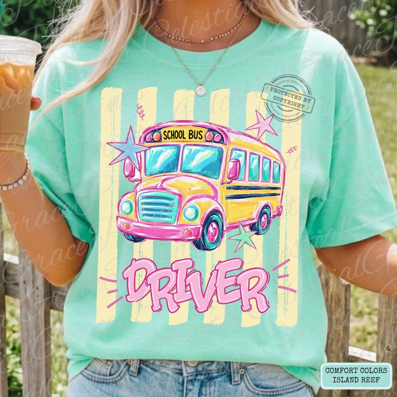 May include: A mint green t-shirt featuring a graphic of a yellow school bus with the text "SCHOOL BUS" above it and "DRIVER" below it. The design includes light yellow vertical stripes and pink and blue star accents on the front of the shirt.