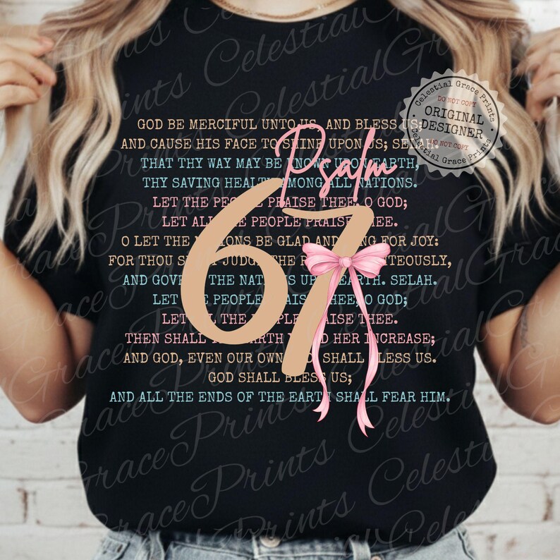 May include: Black t-shirt featuring the text "Psalm 67" with a pink bow and script. The shirt has a religious theme, with a verse printed on the front. The design includes the words "Celestial Grace Prints Designer".