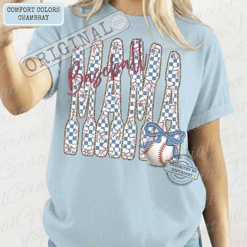 May include: Light blue chambray t-shirt with the text "Baseball Mama" in a stylized design. The letters are filled with a blue and white checkered pattern and baseball graphics. A baseball with a blue bow is featured.