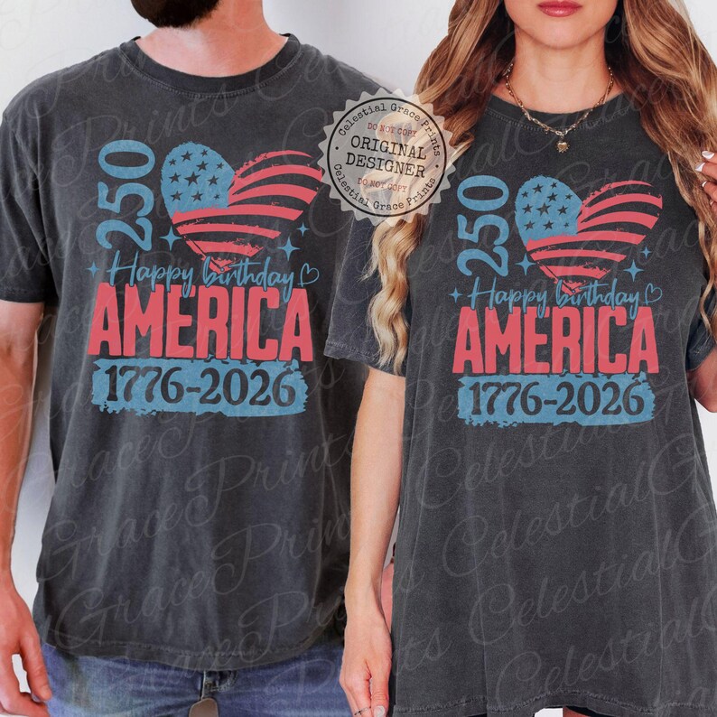 Puede incluir: Camisetas de color gris oscuro con un dise&ntilde;o patri&oacute;tico. El dise&ntilde;o presenta una bandera estadounidense en forma de coraz&oacute;n, el texto "250 Happy Birthday AMERICA 1776-2026" en rojo y azul, celebrando el aniversario de la naci&oacute;n.