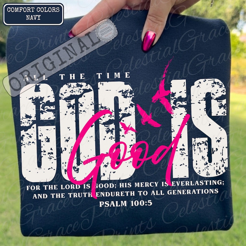 May include: Navy blue Comfort Colors t-shirt with the words "GOD IS GOOD" in distressed white and pink lettering. The shirt also features the text "ALL THE TIME" and Psalm 100:5. A design of pink birds is also included.