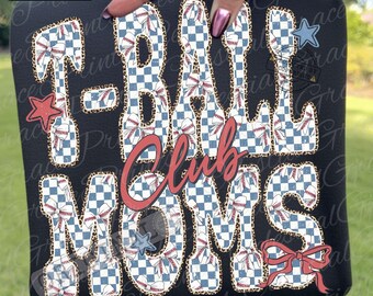 May include: Black t-shirt with the words "T-Ball Club Moms" in a baseball-themed design. The letters are filled with a blue and white checkered pattern and baseballs. Accents include stars and a red bow.