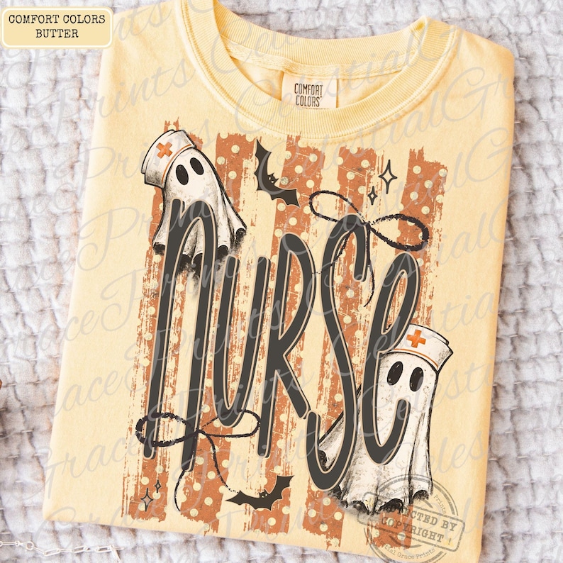 May include: A butter yellow t-shirt featuring a graphic print with the word NURSE in large black script. The design includes two white ghost figures wearing nurse caps with orange crosses, orange vertical stripes, and small black bats.