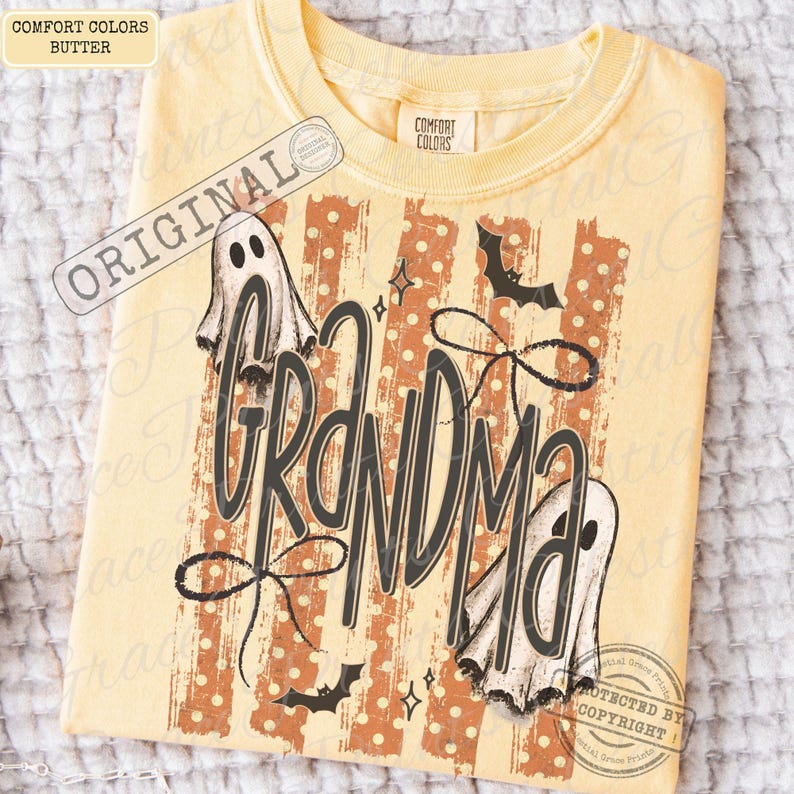 May include: A butter yellow crew neck t-shirt featuring a graphic print with the word Grandma in large dark gray script. The design includes two white ghosts, two black bats, and a background of vertical orange stripes with white polka dots.