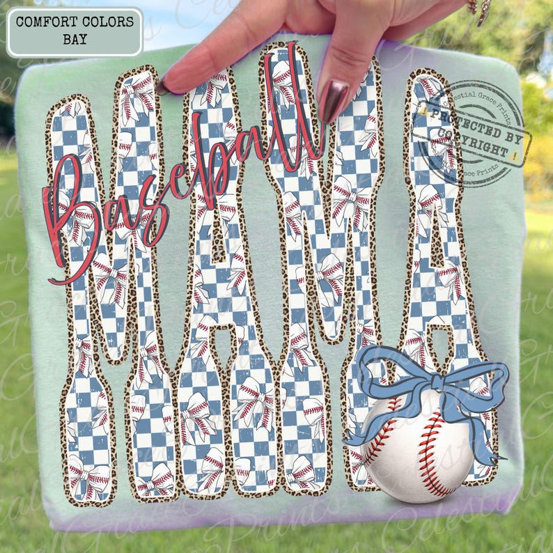 May include: A light green t-shirt with the words "Baseball Mama" in a distressed, red script. The letters are filled with a blue and white checkered pattern and baseball-themed designs. A baseball with a blue bow is at the bottom.