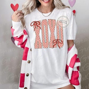 May include: White t-shirt with the word "XOXO" in red and white checkered pattern letters, adorned with red bows. The shirt is paired with a white cardigan featuring red and white checkered sleeves. The image includes a small circular logo that says "Celestial Grace Prints".