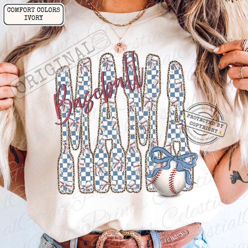 May include: Ivory-colored t-shirt with a baseball-themed design. The word "Baseball" is written in pink script, with baseball bats featuring a blue and white checkered pattern and leopard print accents. A baseball with a blue bow is also featured.