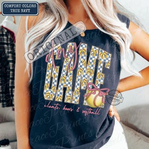 May include: Navy blue tank top with the words "Game Day" in pink script and a checkered pattern. A softball with a pink bow is featured below the text. The words "cleats, bows & softball" are written in pink script.