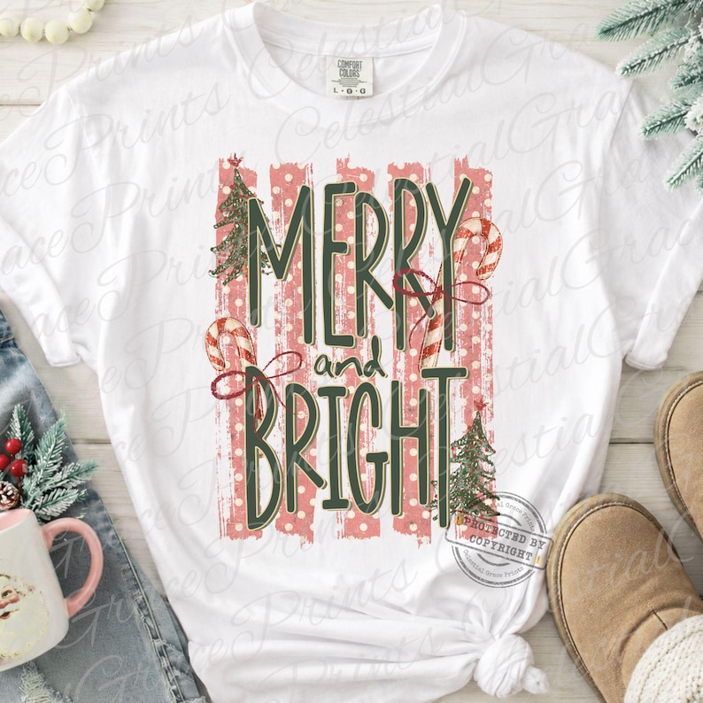 May include: A white short-sleeve t-shirt featuring a graphic print with the text MERRY and BRIGHT in dark green letters. The design includes red and white striped candy canes, green Christmas trees, and vertical red polka dot stripes.