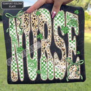 May include: Black sweatshirt with the word "Nurse" in a unique design. The word features a mix of leopard print, green checkered patterns, and shamrock accents. Green bows and the text "Comfort Colors Black" are also visible.