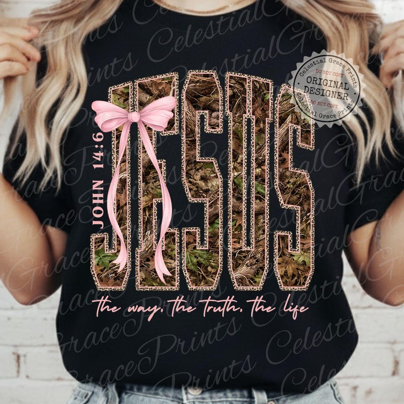 May include: Black t-shirt with the word "JESUS" in a camouflage and leopard print design. A pink bow and the text "JOHN 14:6" are on the left side. The phrase "the way, the truth, the life" is at the bottom.