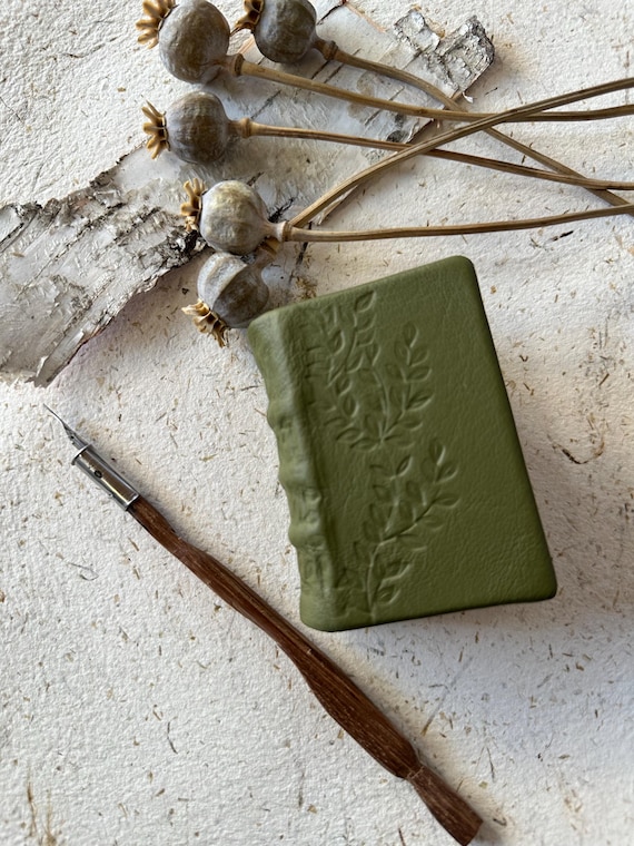Blind-tooled medieval-bound journal with a spring bloom motif — the traditional bookbinding craft technique alone makes this genuinely rare on Etsy.