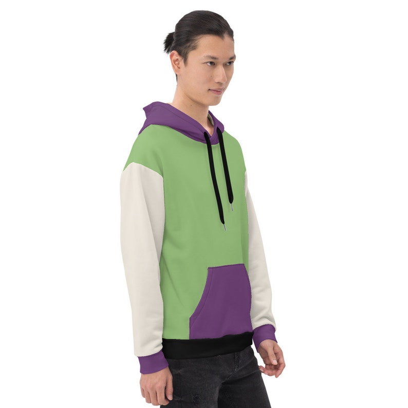Puede incluir: Una sudadera con capucha verde, morada y blanca con un cord&oacute;n negro. La sudadera tiene un bolsillo canguro en la parte delantera.