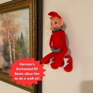 A Christmas elf stuck to the wall while wearing his Enchanted Elf Boots.