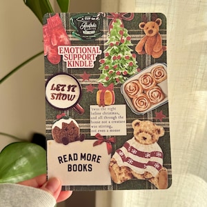 May include: A decorative card with a festive theme. It features a green plaid background with various Christmas-themed stickers, including a Christmas tree, teddy bears, and the text "Let it Snow" and "Read More Books".