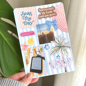 May include: A decorative card with a beach theme, featuring blue and white stripes, a palm tree, and the words "Seas The Day" and "Kindle Girly." Other elements include a photo of a sunset, a bow, and a starfish.