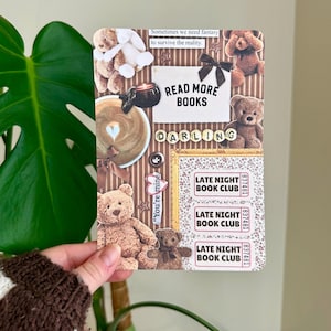 Peut inclure: Une impression de style collage avec des ours en peluche, du café et le texte "Read More Books Darling". Le design comprend un nœud, un cadre doré et des billets "Late Night Book Club". La phrase "Sometimes we need fantasy to survive the reality" est également présente.
