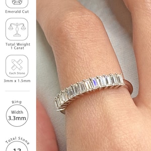 May include: A silver ring with 13 emerald-cut stones. The ring has a total weight of 1 carat, with each stone measuring 3mm x 1.5mm. The ring's width is 3.3mm.