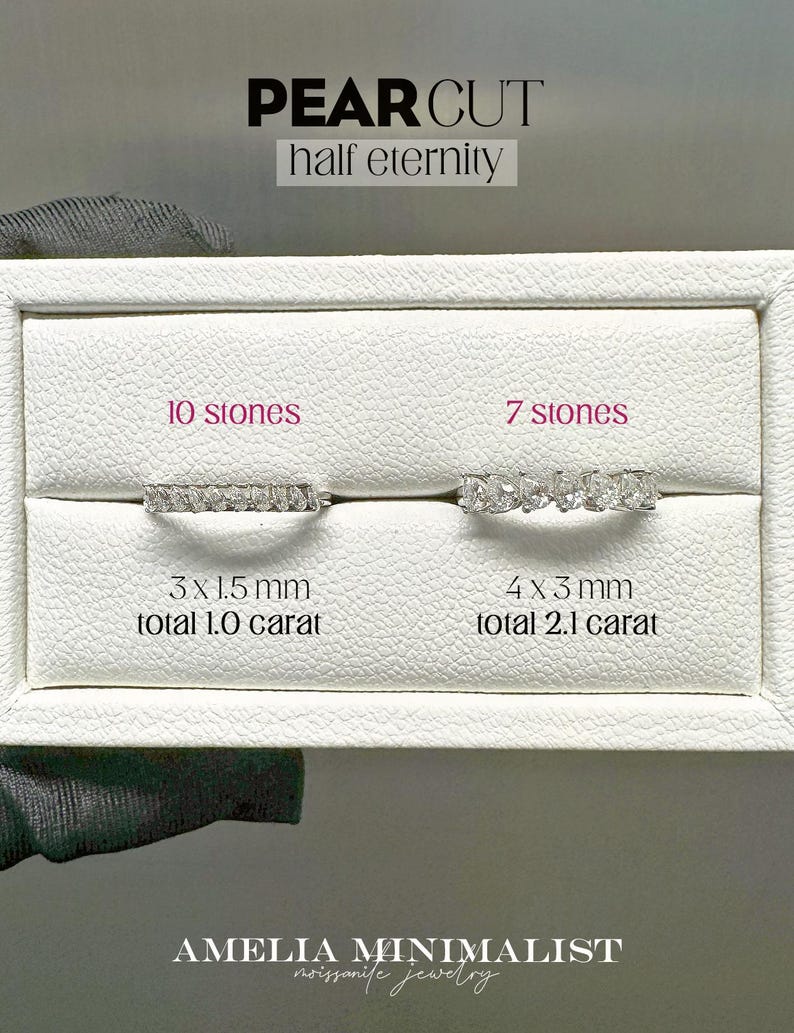 K&ouml;nnte beinhalten: Zwei birnenf&ouml;rmige Diamantringe auf einem wei&szlig;en Display. Der Ring links hat 10 Steine, ist 3 x 1,5 mm gro&szlig; und 1,0 Karat schwer. Der Ring rechts hat 7 Steine, ist 4 x 3 mm gro&szlig; und 2,1 Karat schwer. Der Text "PEAR CUT half eternity" befindet sich oben auf dem Display. Der Text "AMELIA MINIMALIST noissanife jewellery" befindet sich unten auf dem Display.