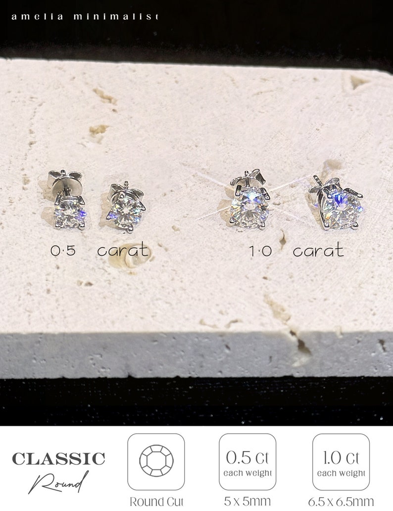 Puede incluir: Dos pares de pendientes de bot&oacute;n plateados con piedras redondas transparentes. Un par est&aacute; etiquetado como 0.5 quilates y el otro como 1.0 quilates. El texto incluye amelia minimalist, 0.5 carat, 1.0 carat, CLASSIC Round, Round Cut, 0.5 Ct each weight 5x5mm, 1.0 Ct each weight 6.5x6.5mm.
