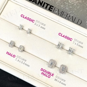 May include: A white display case with four rows of emerald cut moissanite earrings. The earrings are labeled "Classic", "Halo", and "Double Halo" with the carat weight and dimensions of each style.
