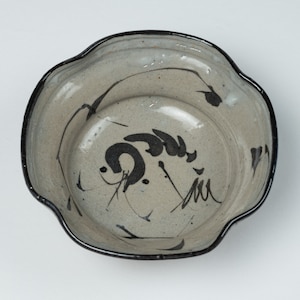 May include: A gray ceramic bowl with a black rim and black brushstroke designs. The bowl has a wavy edge.