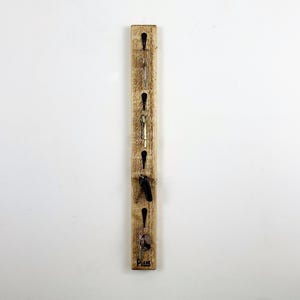 May include: A wooden key holder with five hooks and the word "Plans" engraved on the bottom.