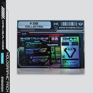 Könnte beinhalten: Ein holografisches Aufkleberpaket mit futuristischem Design. Die Aufkleber zeigen Texte wie "V.02 COLLECTION", "GHOSTRUNEHE" und "CAUTION". Das Farbschema umfasst Schwarz, Silber, Grün und holografische Elemente.