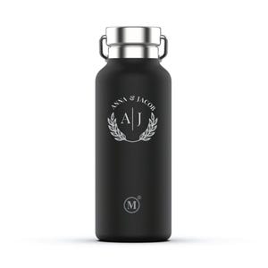 May include: Black stainless steel water bottle with a silver lid and a white monogram that says "Anna & Jacob A J" in a circle with a laurel wreath around it. The bottle has a small "M" logo on the bottom.